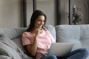 woman smiling using laptop in her home